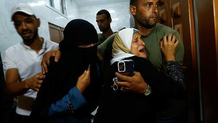 Familia palestina tras el asesinato de su hijo en la frontera con Gaza en manos de las fuerzas israelíes. Foto: Reuters.