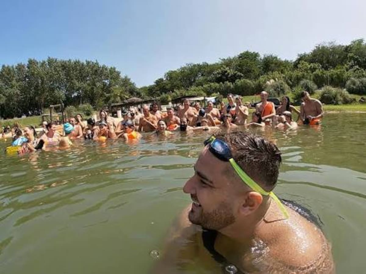 Nadadores compiten en una prueba de aguas abiertas en el mar durante un evento deportivo.