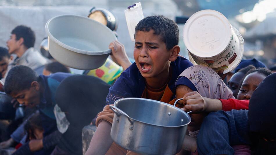 Niños palestinos esperan recibir alimentos durante el Ramadán, en Rafah. Efe