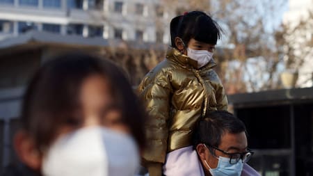 Aumentan los casos de neumonía en China. Un hombre carga a su hijo hacía el hospital. Reuters.