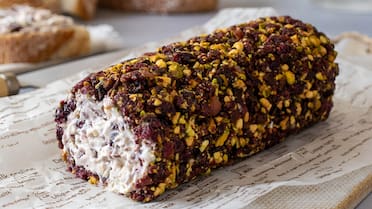 Un llamativo aperitivo para Navidad: la receta del rulo de queso con jamón serrano, pistachos y arándanos