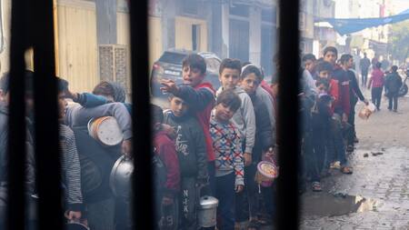 Niños palestinos esperan recibir comida cocinada en una cocina benéfica, en Rafah, Gaza. Reuters