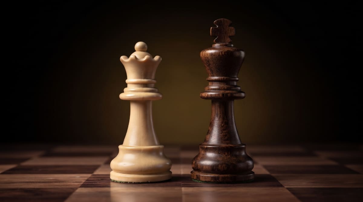 La diferencia con el rey resulta especialmente visible: mientras este suele tener una cruz sobre su corona, la dama conserva un remate redondeado que permite identificarla.