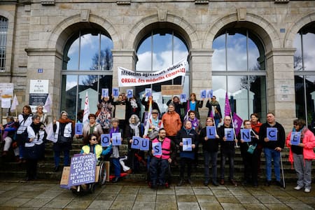 Miembros de colectivos de mujeres , médicos, ONG y sindicatos se manifiestan frente al palacio de justicia en el primer día del juicio contra Le Scouarnec. Foto: REUTERS/Stephane Mahe.