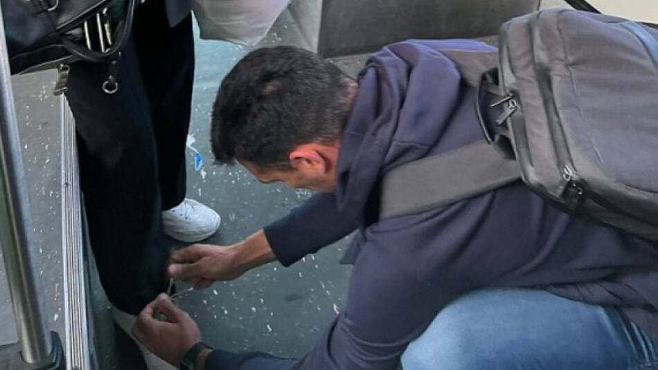 Lionel Scaloni atándole los cordones a una mujer en un colectivo. Foto: NA.
