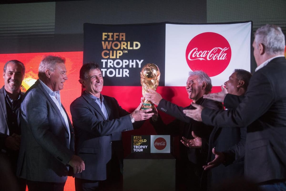 Integrantes del plantel campeón mundial del 78 y 86 posan con la Copa del Mundo en el predio de la AFA en Ezeiza