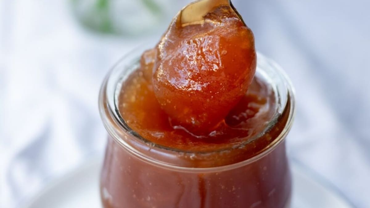 Frascos de mermeladas artesanales exhibidos en una feria gastronómica junto a productos regionales elaborados por productores locales.