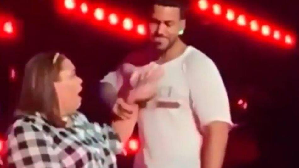 Romeo Santos y fan en escenario