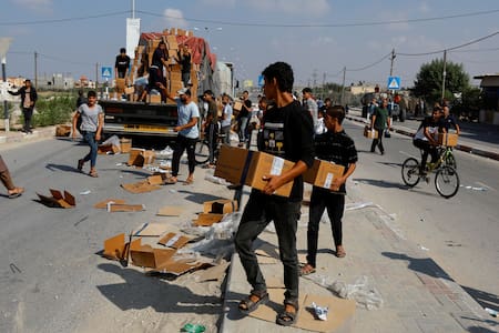 Palestinos recibiendo paquetes de ayuda humanitaria. Gaza. Reuters.