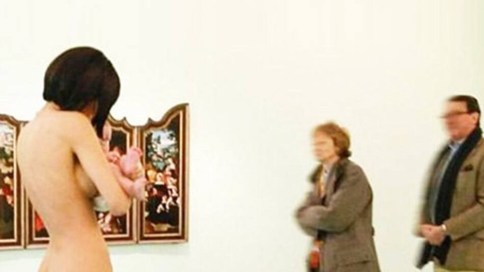Mujer se pasea desnuda con un bebé por un museo