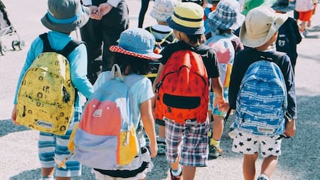 Niños pequeños con mochilas. Foto: Unsplash.