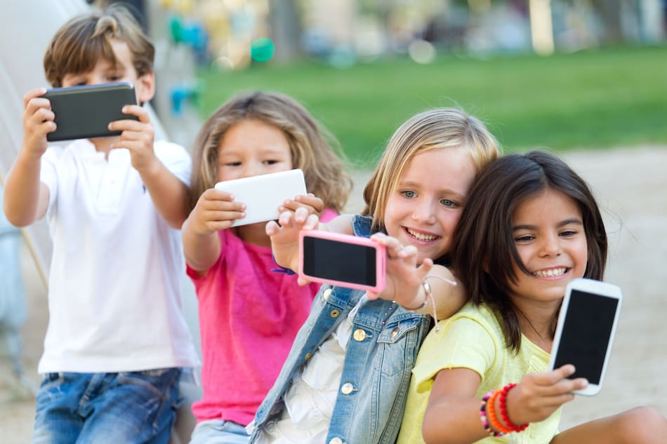 Niños usando el celular. Foto Freepik