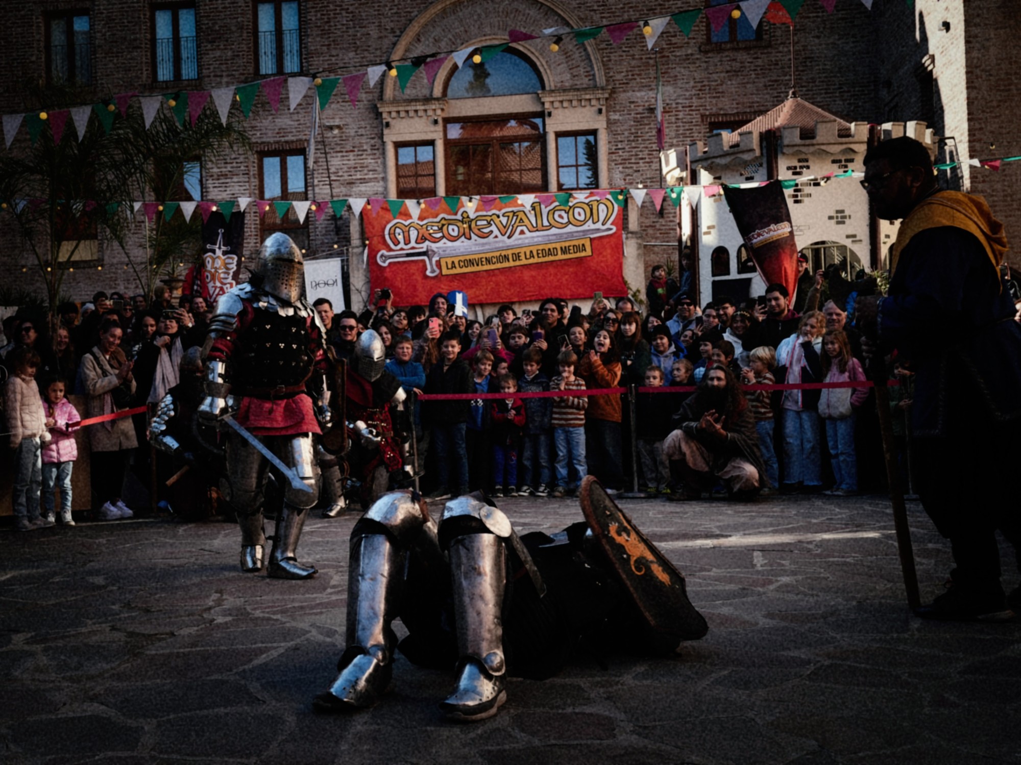 Recreación histórica en MedievalCon con caballeros medievales, fuerte de madera, combate en armaduras y público familiar en el Parque Yrigoyen de San Martín.