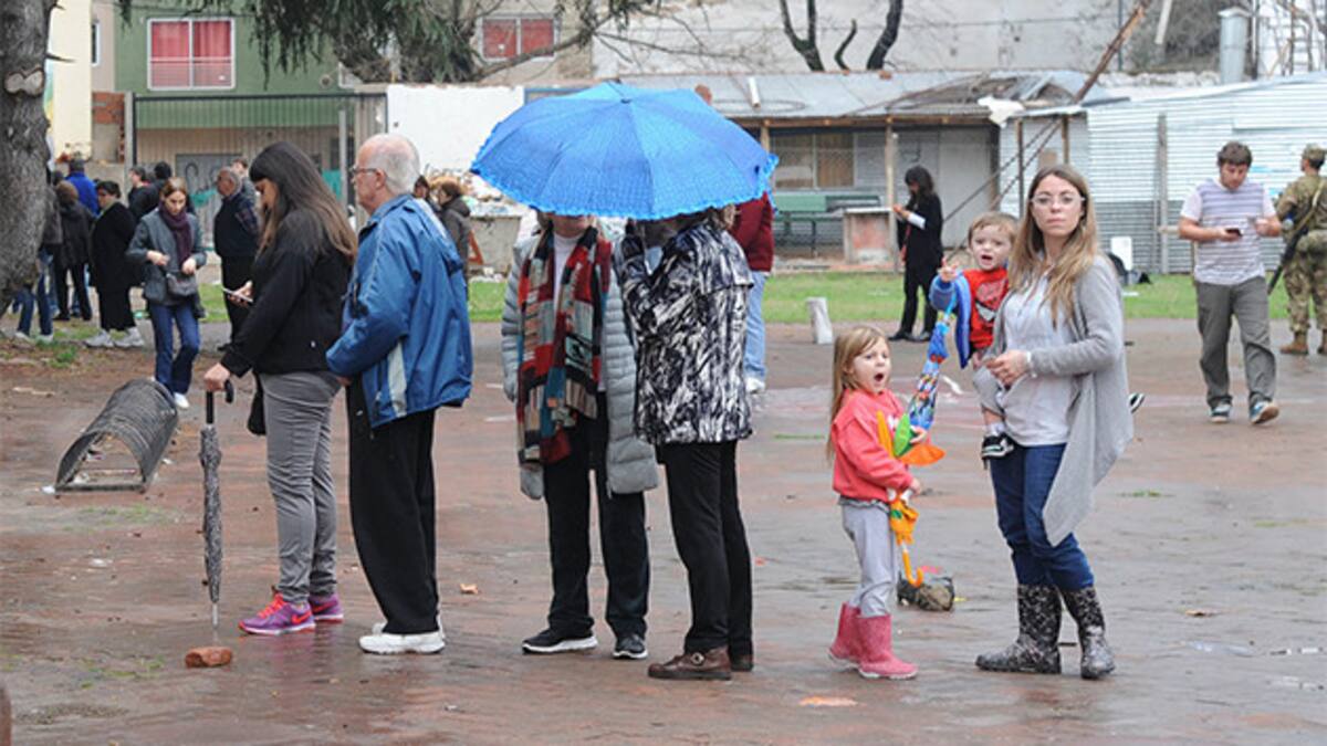 Gente votando bajo la lluvia
