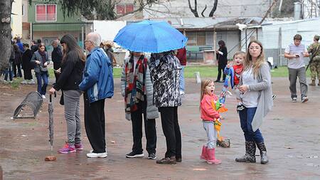 Gente votando bajo la lluvia