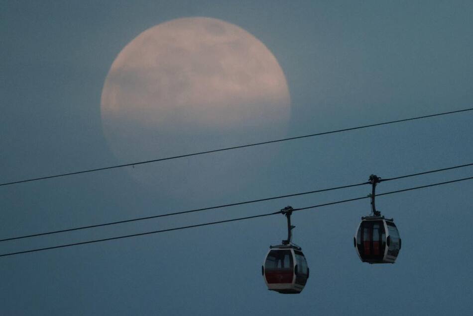 Superluna rosa, se eleva sobre el teleférico de Emirates Air Line en Londres, Reino Unido HANNAH MCKAY - Reuters
