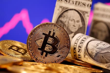 Bitcoin y dólares, criptomoneda, economía, Reuters.