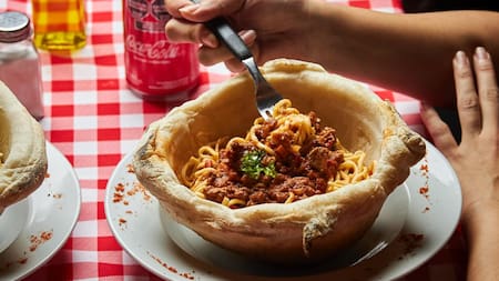 Un bodegón brilla por servir las pastas en un volcán de masa de pizza: dónde queda