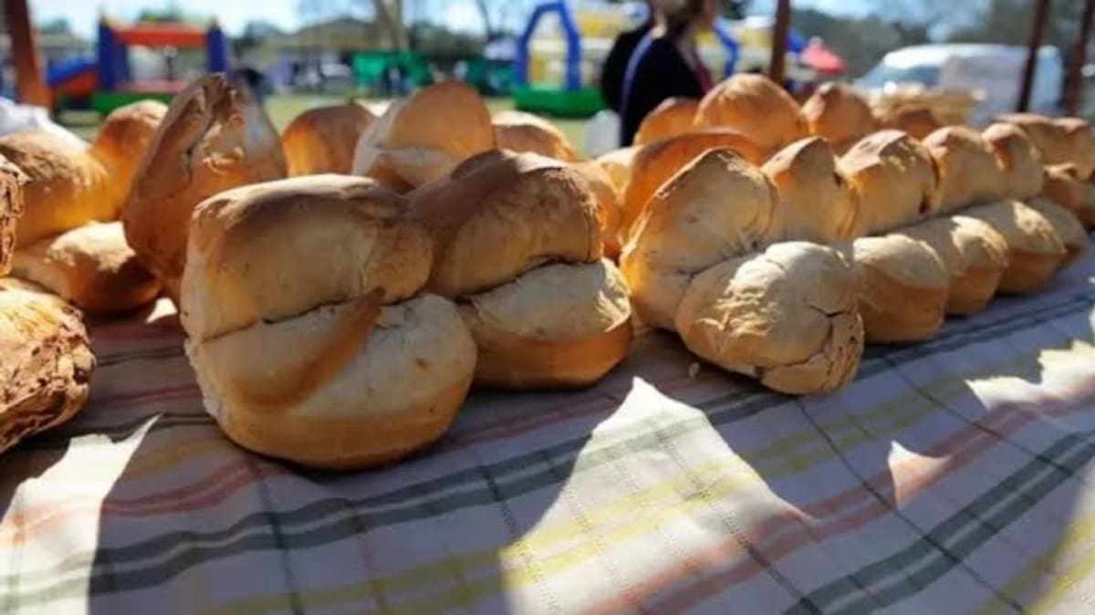Multitud reunida durante la Fiesta de la Galleta de Campo en Tomás Jofré con canastos de pan artesanal en primer plano.