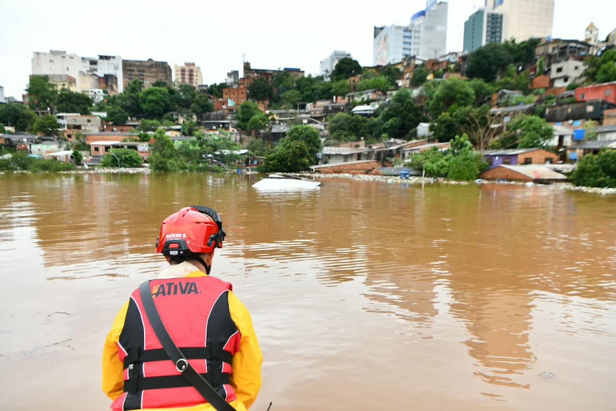 Trabajador de rescate observa la inundación en un barrio de Paraguay.