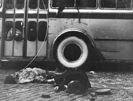 Víctima caída junto a vehículos mirando hacia el este en las inmediaciones de la entrada del Ministerio de Haciendo en Avenida Paseo Colón
