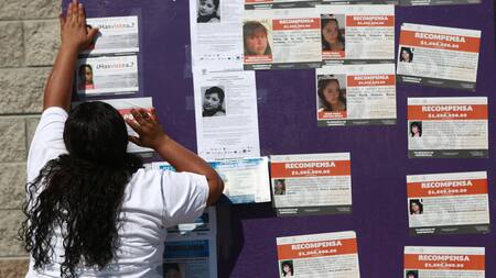 Madres pegando fotos de los migrantes desaparecidos en forma de protesta. Foto: EFE