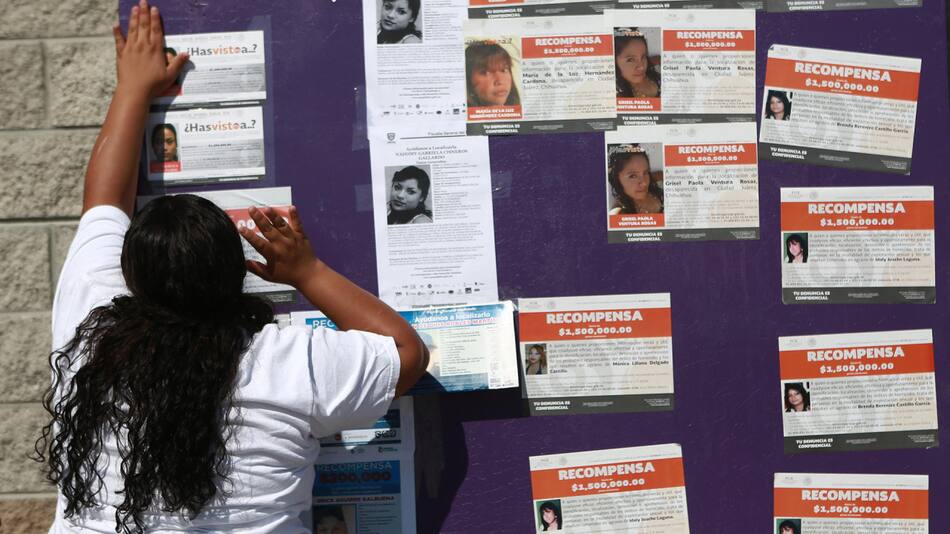 Madres pegando fotos de los migrantes desaparecidos en forma de protesta. Foto: EFE
