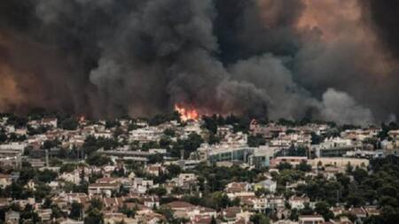 La columna de humo cubre las afueras de la ciudad capital de Grecia, Atenas.