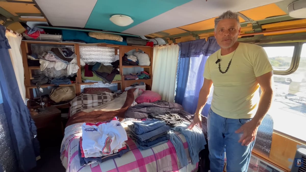 Jorge junto al colectivo de doble piso que transformó en su casa frente al mar en Punta Médanos