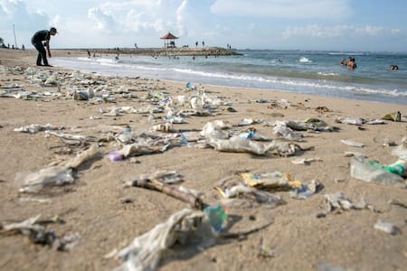 En la imagen de archivo, un voluntario retira la basura que se acumula en la orilla de la playa Sanur en Bali (Indonesia). EFE/ Made Nagi