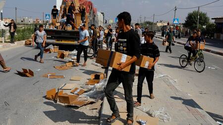 Palestinos recibiendo paquetes de ayuda humanitaria. Gaza. Reuters.