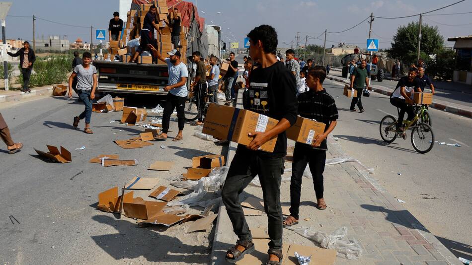 Palestinos recibiendo paquetes de ayuda humanitaria. Gaza. Reuters.