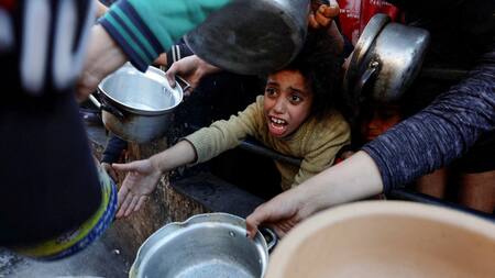 Niños palestinos piden ayuda humanitaria en Gaza. Foto: Reuters.