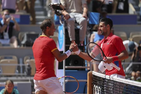 El tenista español Rafa Nadal (i) se despide del serbio Novak Djokovic tras perder en su partido celebrado en el marco de los Juegos Olímpicos de París, este lunes. EFE/ Juanjo Martín.