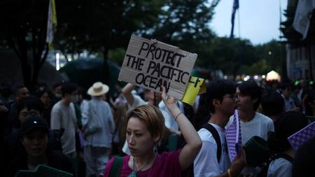 Una mujer sostiene una pancarta durante una protesta contra el plan de Japón de liberar al océano aguas residuales tratadas de la central nuclear de Fukushima. Foto: Reuters.
