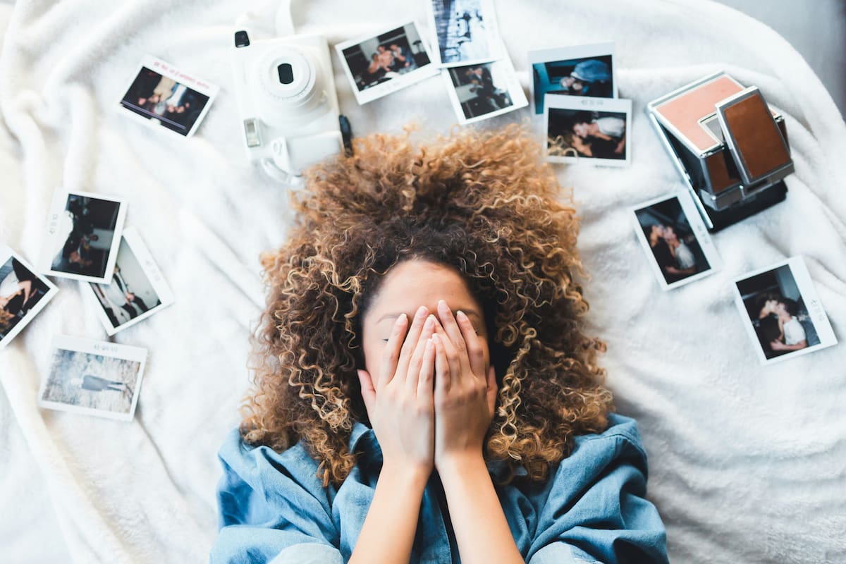 Persona observando fotografías antiguas mientras los recuerdos se transforman en su memoria.