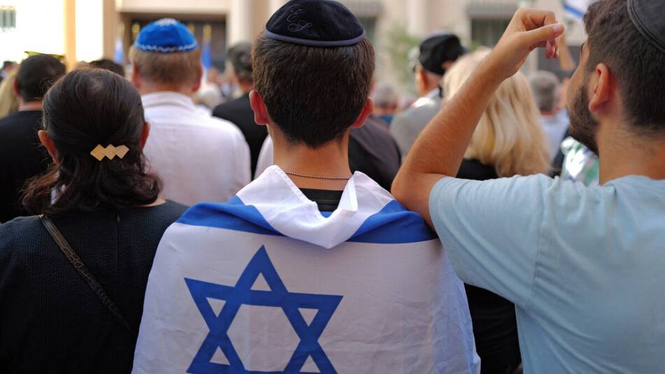 Joven con una bandera de Israel sobre su espalda. Foto: AMIA.