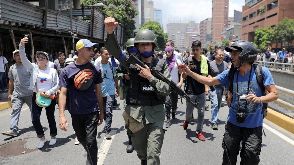 Un miembro de la Guardia Nacional venezolana hace gestos, luego de unirse a manifestantes antigubernamentales en una marcha, mostrando su apoyo al líder de la oposición Juan Guaido en Caracas, Reuters