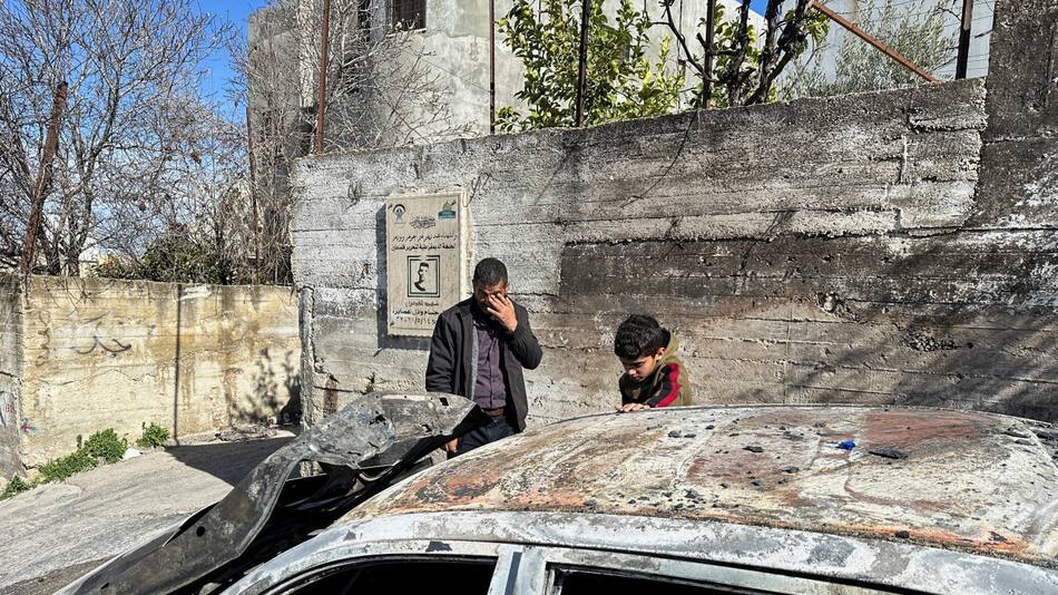 Palestinos revisan un coche dañado tras un ataque de colonos israelíes. Foto: Reuters