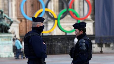 Agentes de Francia hacen guardia cerca de los anillos olímpicos que se exhiben para los Juegos de Verano de París 2024. Foto: Reuters.