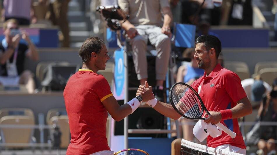 El tenista español Rafa Nadal se despide del serbio Novak Djokovic tras perder en su partido celebrado en el marco de los Juegos Olímpicos de París, este lunes. EFE/Juanjo Martín.