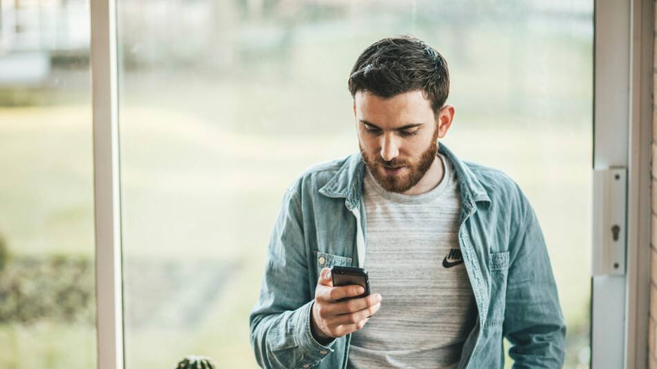 Hombre usando celular. Unplash