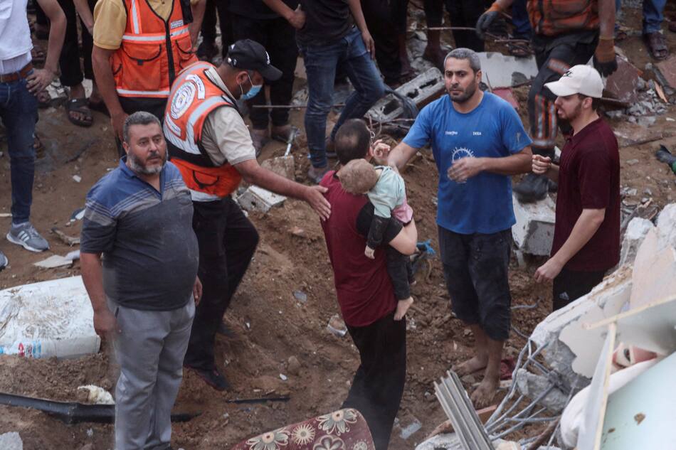 Palestinos encuentran un niño en los escombros luego de un bombardeo a una estructura residencial en Gaza. Reuters.