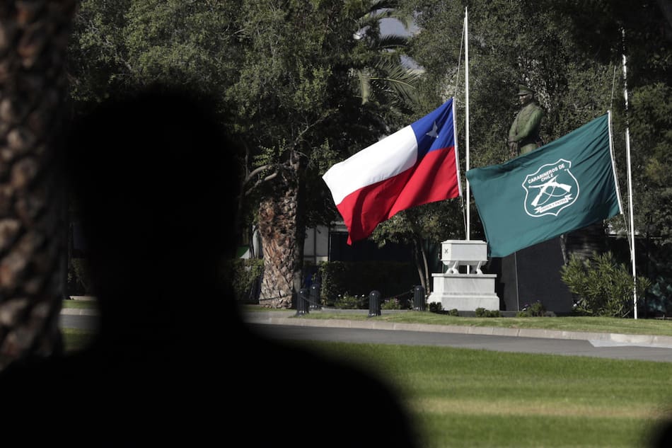Las banderas de Chile y la institución de Carabineros, a media asta. Foto: EFE