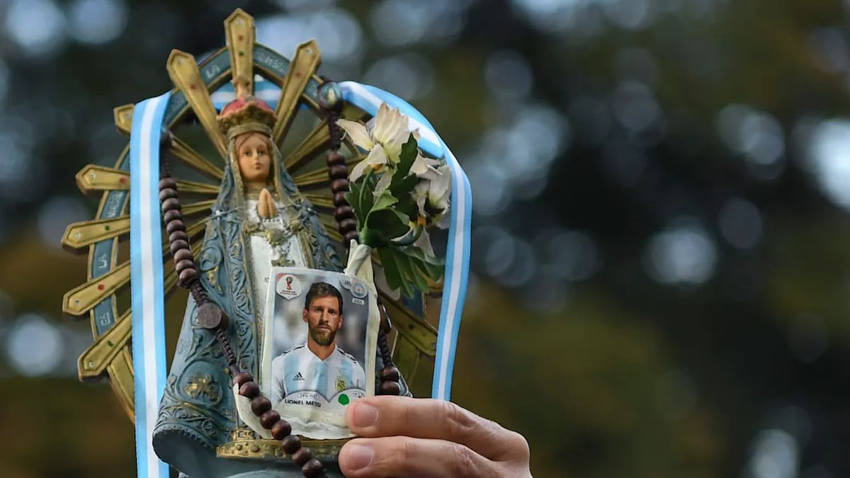 Un hincha de Argentina sostiene una imagen de la Virgen