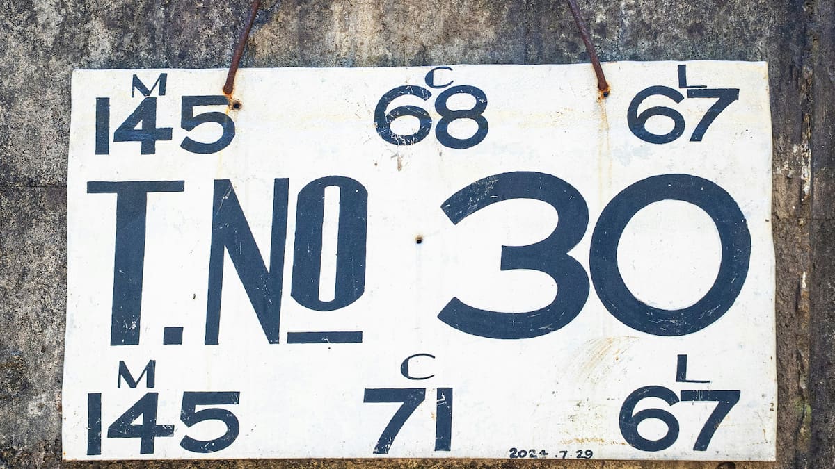 Un cartel blanco con números y "t.no 30"