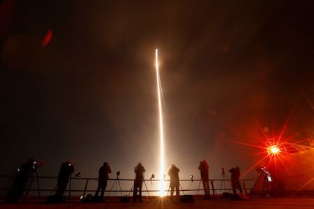 Varias personas toman fotografías durante el lanzamiento del cohete Vulcan. Foto: Reuters.
