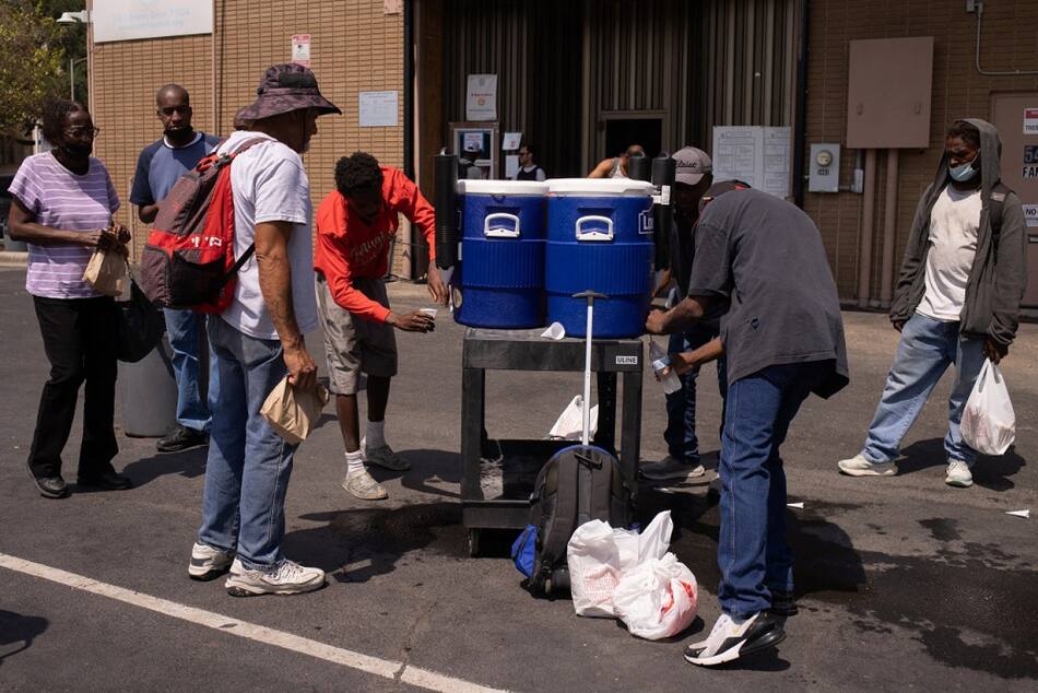 La gente bebe agua fría fuera de la Coalición de Ayuda de Emergencia durante una ola de calor en Houston, Texas, Estados Unidos. Foto: Reuters.
