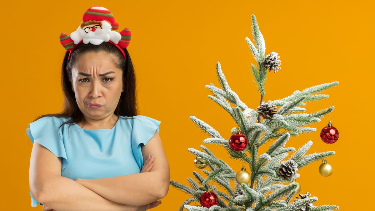 Árbol de Navidad acompañado por una mujer ofuscada
