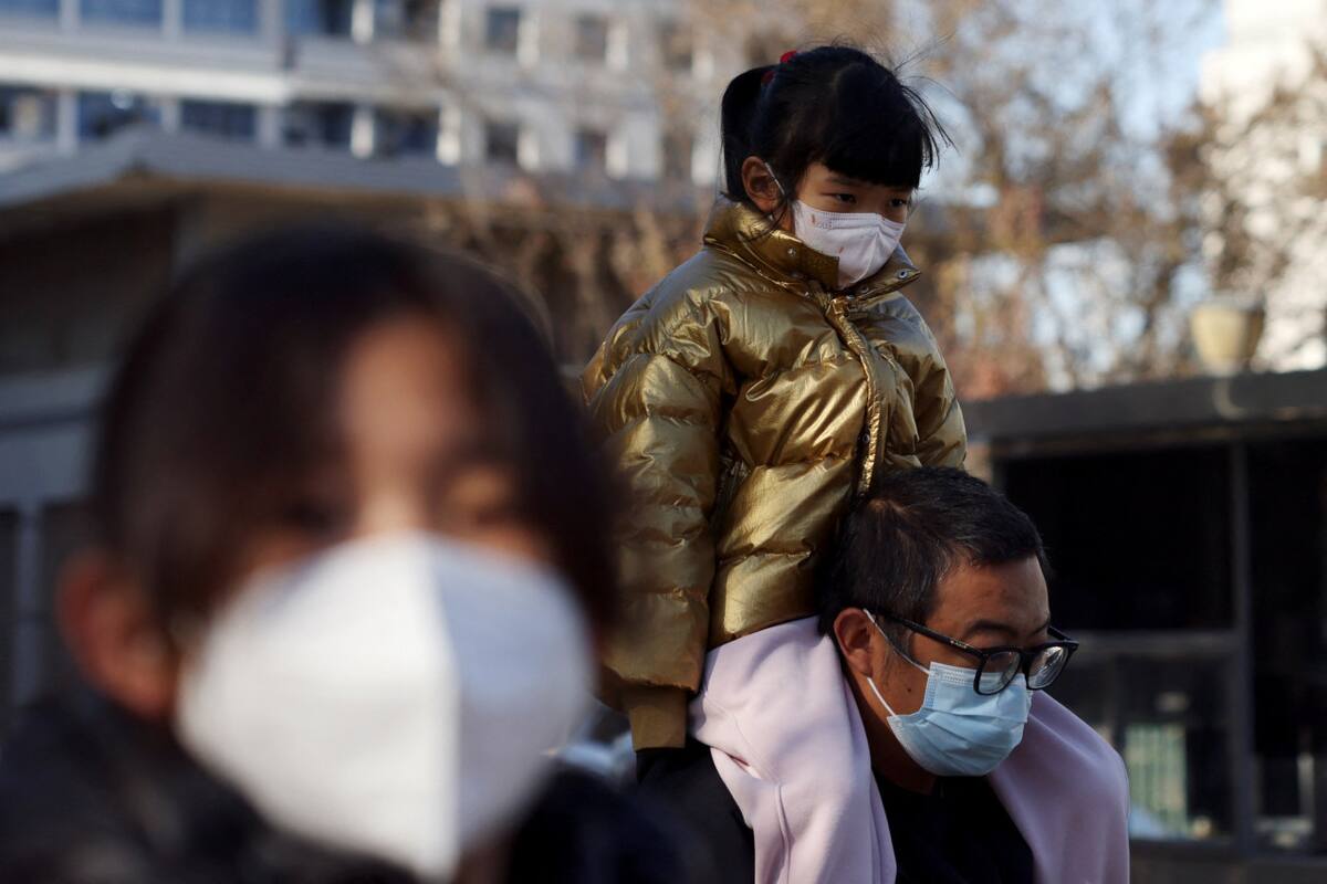 Aumentan los casos de neumonía en China. Un hombre carga a su hijo hacía el hospital. Reuters.